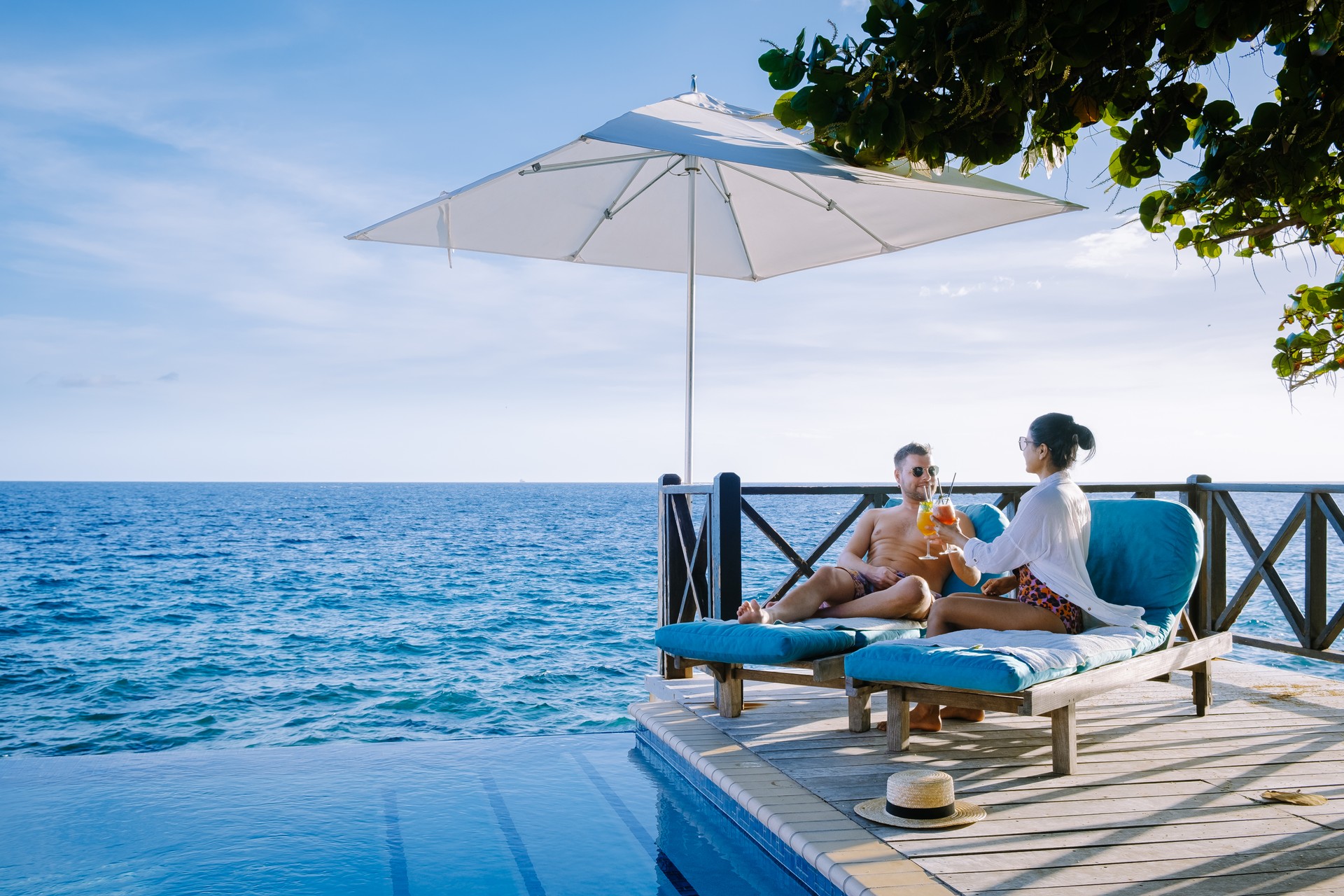 Curacao, couple man and woman mid age relaxing by the swimming pool during vacation, men and girl by pool in Curacao during holiday