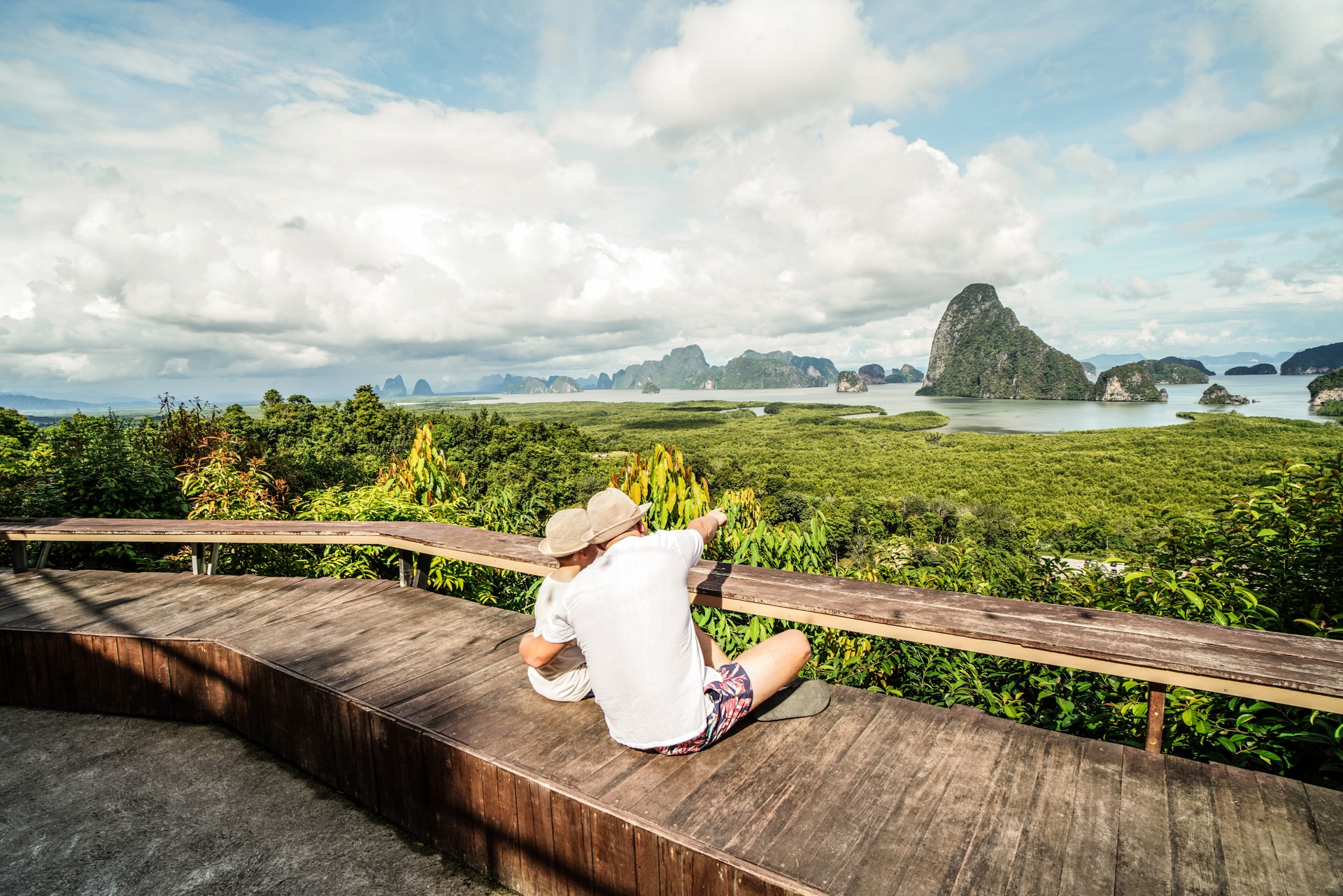 Happy traveler dad and son enjoying Phang Nga bay view point, Tourists relaxing at Samet Nang She in Southern Thailand. Summer vacation concept.